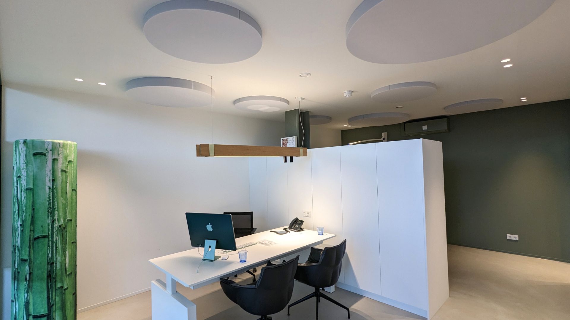 Innenraum einer Praxis mit Schreibtisch und Akustikelementen