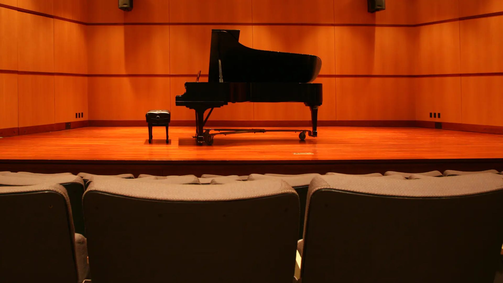 Blick in einen Konzertsaal mit Bühne, Flügel und Sitzreihen