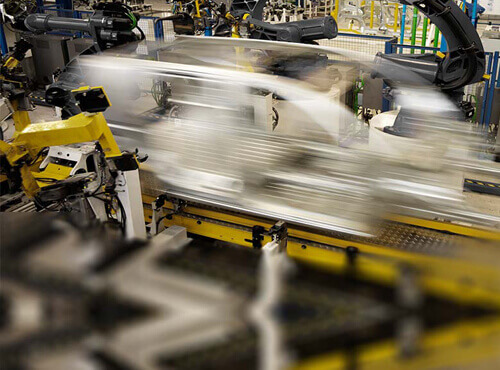 Laute Maschinen im Fahrzeugbau Eine Industrieanlage im Fahrzeugbau erzeugt Lärm..