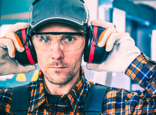 Gehörschutz und Schallschutz am Arbeitsplatz Ein Arbeiter verwendet Gehörschutz, um sich vor Lärm zu schützen.