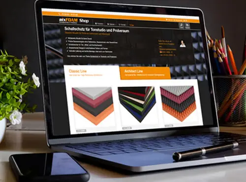 Ein Laptop zeigt den aixFOAM Online Shop mit Schallabsorbern und Schallschutz Produkten zur Auswahl.