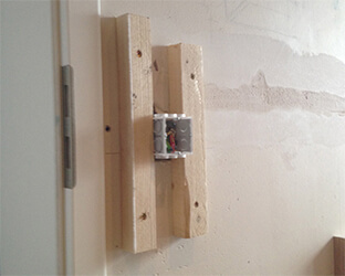 Square-profile batons along the light switch form the base on which the cover is later screwed through the fabric.