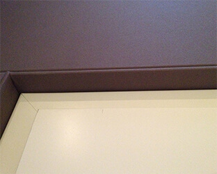 Visible edge covered with acoustic fabric on a door in the home cinema